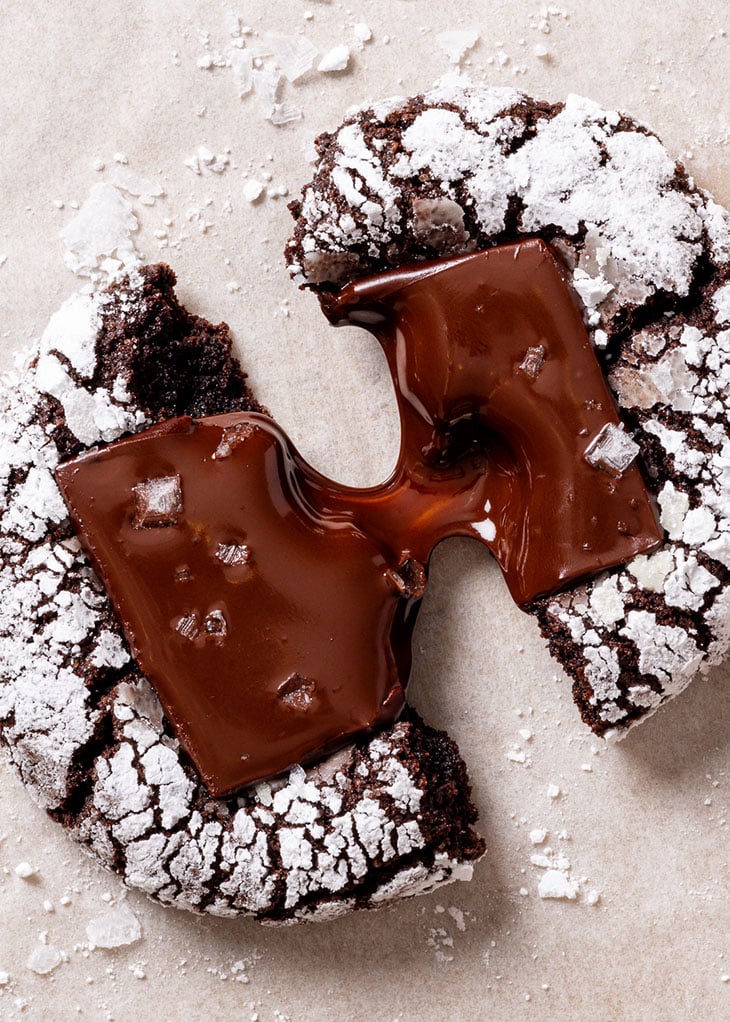 Close-up vies of a chocolate crinkle cookie with a molten chocolate centre.